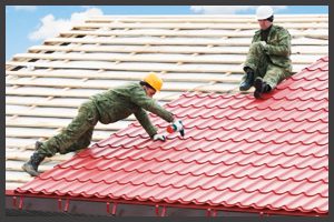 Man Installing Red Metal Roofing